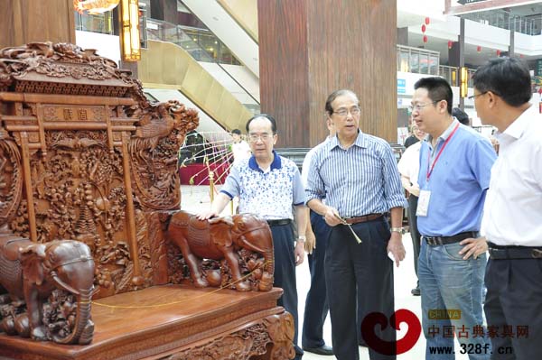 廣東新會(huì)古典家具城有限公司董事長(zhǎng)袁秋耘（右二）為嘉賓講解古典家具制作技藝