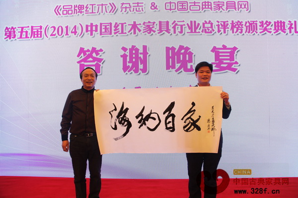 馮文土大師（左）的墨寶“海納百家”被中山偉明軒紅木董事長張石乃（右）拍得
