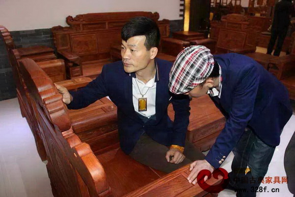 在唐明居紅木董事長胡高華的帶領(lǐng)下，劉金笑導(dǎo)演認(rèn)真欣賞展廳內(nèi)的每一款紅木家具