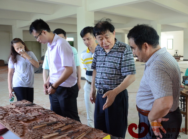 鴻庭軒董事長陳戴青(右一)為全國工商聯(lián)民間文物藝術(shù)品商會會長宋建文(右二)一行介紹鴻庭軒雕刻工藝 鴻庭軒董事長陳戴青(右一)為全國工商聯(lián)民間文物藝術(shù)品商會會長宋建文(右二)一行介紹鴻庭軒雕刻工藝