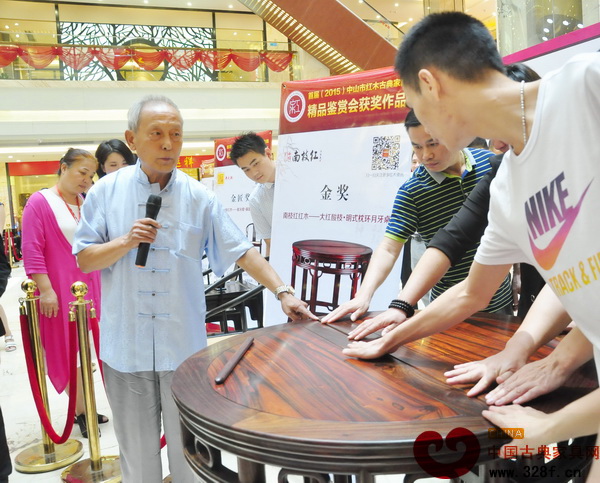 故宮家具修復專家、古典家具傳承工藝大師王秀林請消費者通過觸摸感受《大紅酸枝·明式枕環月牙桌》的精湛工藝 故宮家具修復專家、古典家具傳承工藝大師王秀林請消費者通過觸摸感受《大紅酸枝·明式枕環月牙桌》的精湛工藝
