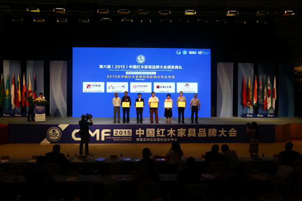 故宮博物院副研究員周京南（右一）、中國明式家具研究所所長濮安國（左一）為“2015年中國紅木家具特別影響力專業市場”獲獎企業頒獎（從左至右分別是：富雅紅木樓、新會古典家具成、中山紅博城、東陽中國木雕城、中山遠揚紅木家具批發市場）