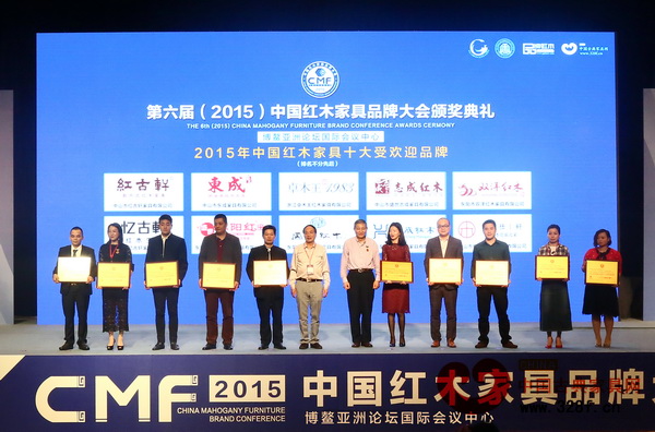 興成紅木總經(jīng)理張靜怡（右一）上臺(tái)接受“2015年中國(guó)紅木家具十大受歡迎品牌”頒獎(jiǎng)