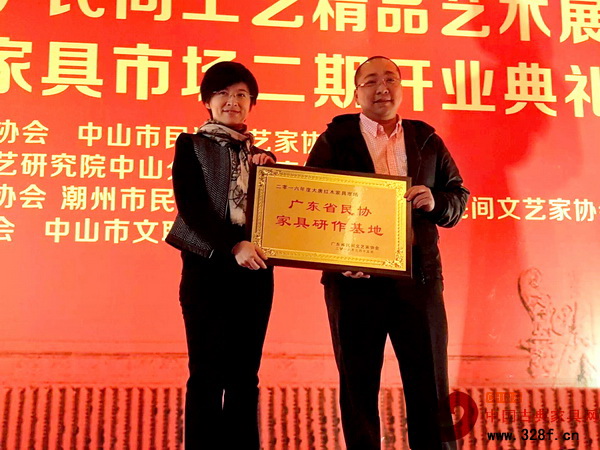 廣東省紅木文化協會秘書長朱琪（左）為大唐紅木家具市場頒發廣東省民協家具研作基地牌匾，大唐紅木家具市場總經理方君揚接受頒牌