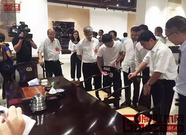 區氏臻品總經理區錦澤(右五)為調研團介紹其紅木家具的工藝特色 區氏臻品總經理區錦澤(右五)為調研團介紹其紅木家具的工藝特色