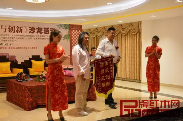 居典紅木董事長尹付林向伍炳亮大師送上“傳承創新，獨領風騷”的錦旗