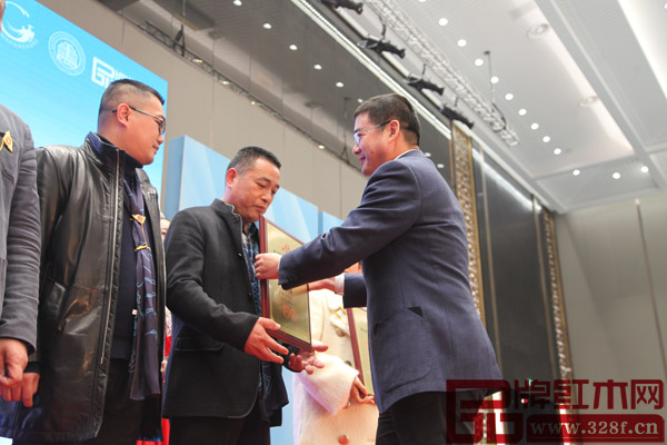 中國木材與木制品流通協會副會長車暢給興成紅木董事長張新貴頒發“2016年中國紅木家具行業十大受歡迎品牌”
