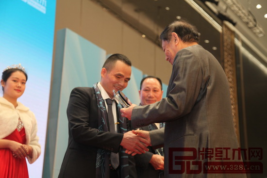 全國工商聯執委、全聯民間文物藝術品商會會長宋建文為雅仕軒董事長陳君頒發“2016年中國紅木家具十大風云企業家”獎杯