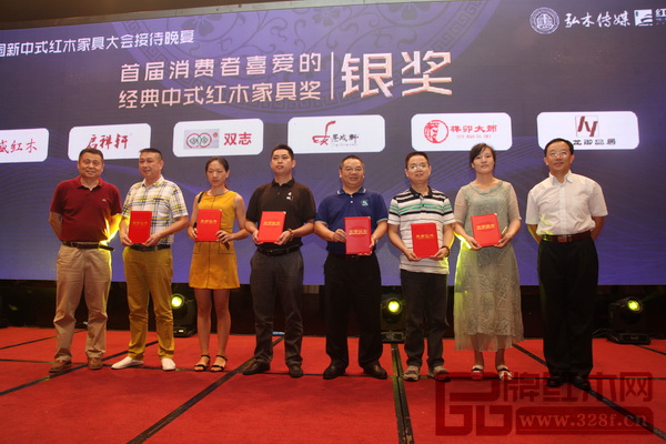 華南農業大學博士生導師李凱夫(右一)、明清家具研究學者張輝(左一)為“首屆消費者喜愛的經典中式紅木家具獎”銀獎獲獎者榫卯大師頒發證書,董事長王強堂(左二)上臺接受頒獎 華南農業大學博士生導師李凱夫(右一)、明清家具研究學者張輝(左一)為“首屆消費者喜愛的經典中式紅木家具獎”銀獎獲獎者榫卯大師頒發證書,董事長王強堂(左二)上臺接受頒獎