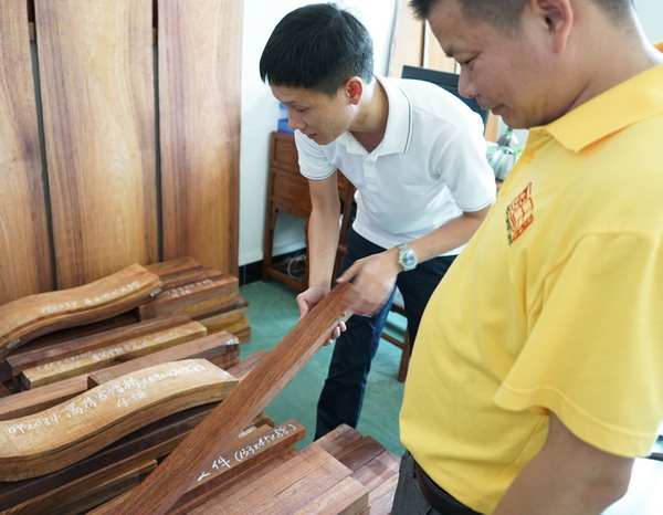 區氏臻品總經理區錦澤(左)與工匠一同嚴把黃花梨選料 區氏臻品總經理區錦澤(左)與工匠一同嚴把黃花梨選料
