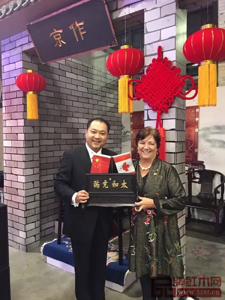 太和木作董事長(zhǎng)關(guān)毅先生（左）向加拿大前副總理希拉·科普斯女士贈(zèng)送“太和充滿”故宮微型匾額
