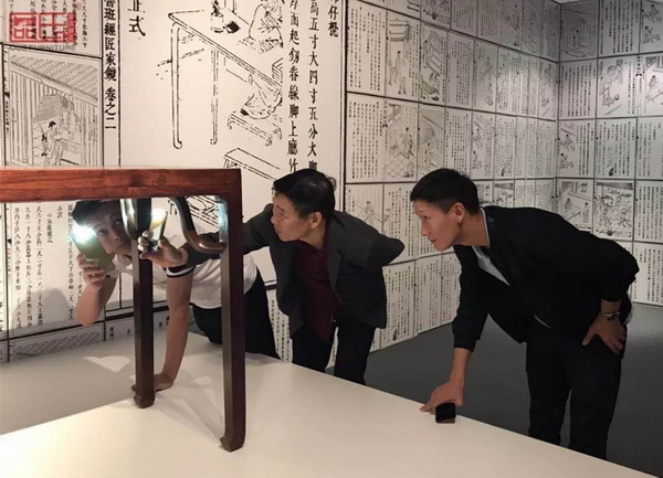 區氏臻品董事長區勝春（右二）、總經理區錦澤（右一）用手機電筒在看家具 