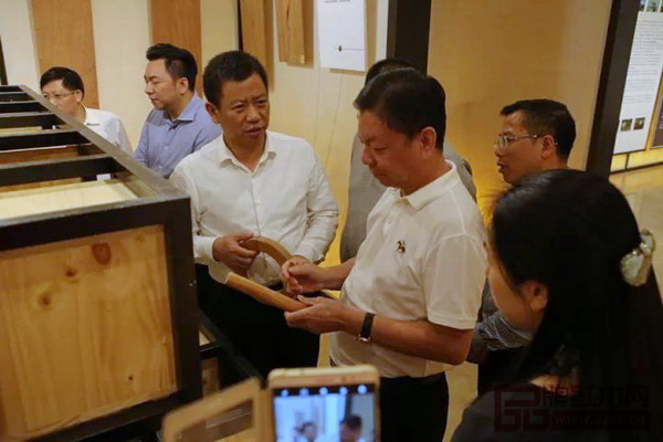 中國傳統工藝大師、國壽紅木董事長陳國壽(右二)為桂陽縣委書記彭生智(左三)介紹紅木家具特有的榫卯結構 中國傳統工藝大師、國壽紅木董事長陳國壽(右二)為桂陽縣委書記彭生智(左三)介紹紅木家具特有的榫卯結構
