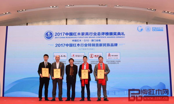 全國工商聯第十一屆執委、全聯民間文物藝術品商會特邀會長、全聯民間文物藝術品商會藝術紅木家具專業委員會會長宋建文（中）為“2017中國紅木行業特別貢獻民族品牌”獲獎企業頒發獎牌