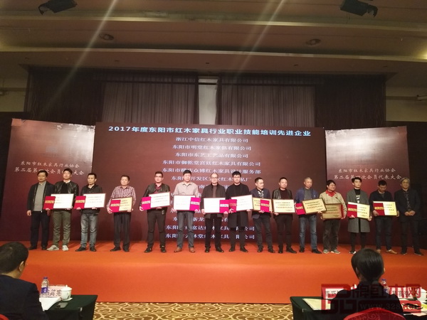 明堂紅木與會代表(左三)上臺接受“2017年度東陽市紅木家具行業職業技能培訓先進企業”榮譽稱號 明堂紅木與會代表(左三)上臺接受“2017年度東陽市紅木家具行業職業技能培訓先進企業”榮譽稱號