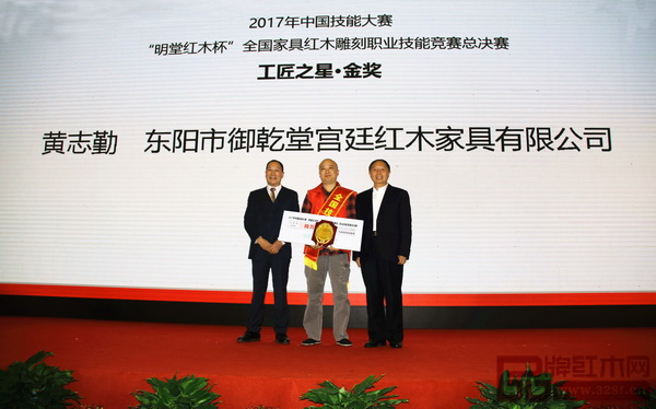 第十一屆全國政協(xié)提案委員會(huì)副主任、原勞動(dòng)和社會(huì)保障部副部長(zhǎng)、中國輕工業(yè)聯(lián)合會(huì)原會(huì)長(zhǎng)步正發(fā)（右一）為御乾堂選手黃志勤頒發(fā)“工匠之星·金獎(jiǎng)”牌匾，御乾堂紅木董事長(zhǎng)馬海軍上臺(tái)見證