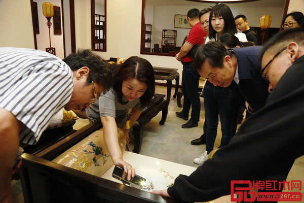 晟寶紅木創始人叢東云（左二）經常熱情接待各界領導賓客蒞臨企業參觀，為他們詳細講解紅木文化