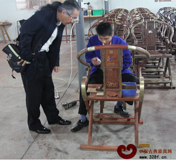 濮安國正在源天福工廠認真觀看工匠生產制作交椅