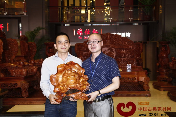 雅仕軒紅木總經(jīng)理(左)贈予加盟商木雕工藝品
