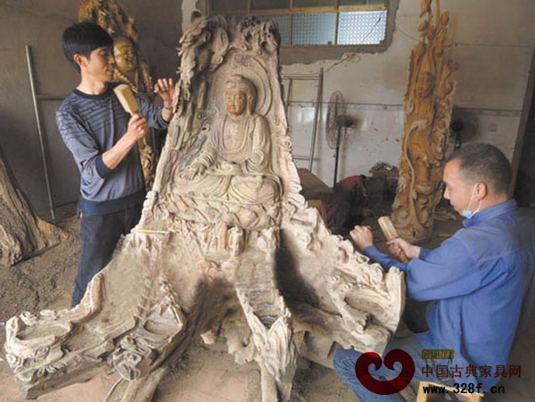 王建明(左)與工人一起合作雕刻