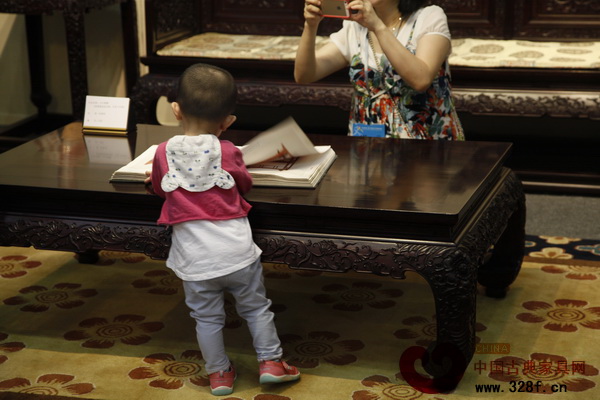 孩子在伍氏興隆展廳內翻看古典家具書籍