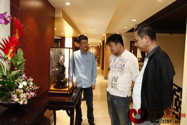 區(qū)氏臻品總經(jīng)理區(qū)錦澤(左一)帶領(lǐng)黎毅藝(中)等區(qū)氏臻品家具發(fā)燒友參觀區(qū)氏展廳