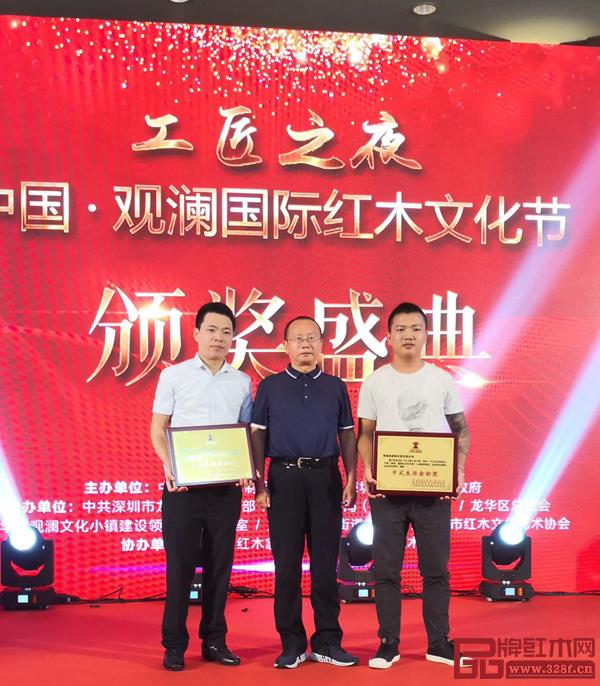 故宮博物院研究員、明清宮廷家具專家周京南（中）為第六屆中國（深圳）國際紅木藝術展中式生活金標獎頒發(fā)獎牌，孔連紅木總經(jīng)理李金龍（左）上臺領獎