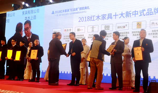 雄業·本木上造榮獲“2018紅木家具十大新中式品牌”,營銷總監符敏捷(右四)上臺接受全聯藝術紅木家具專業委員會專家顧問、中國紅木家具技術專家曹新民的授牌 雄業·本木上造榮獲“2018紅木家具十大新中式品牌”,營銷總監符敏捷(右四)上臺接受全聯藝術紅木家具專業委員會專家顧問、中國紅木家具技術專家曹新民的授牌