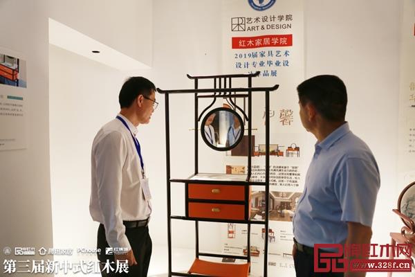 王克（左）參觀“新意思”新中式紅木家具展中展出的高等院校學生作品