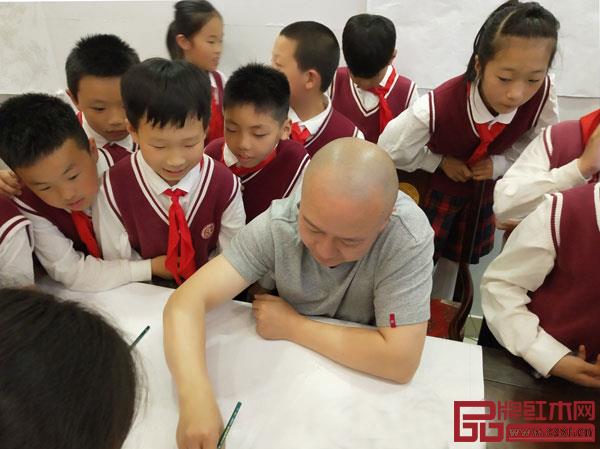 吳寧鎮(zhèn)第四小學(xué)的學(xué)生們圍繞在御乾堂紅木員工——中國傳統(tǒng)工藝美術(shù)大師黃志勤身邊,看其進(jìn)行紅木家具設(shè)計(jì)創(chuàng)作 吳寧鎮(zhèn)第四小學(xué)的學(xué)生們圍繞在御乾堂紅木員工——中國傳統(tǒng)工藝美術(shù)大師黃志勤身邊,看其進(jìn)行紅木家具設(shè)計(jì)創(chuàng)作