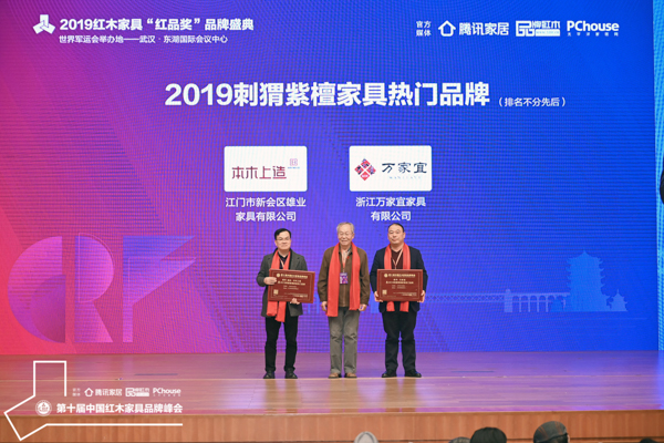 雄業·本木上造摘得“2019刺猬紫檀家具熱門品牌”，董事長鐘超雄（左一）上臺領獎，中央民族大學人體工程學專家蘇垣（中）為其頒獎