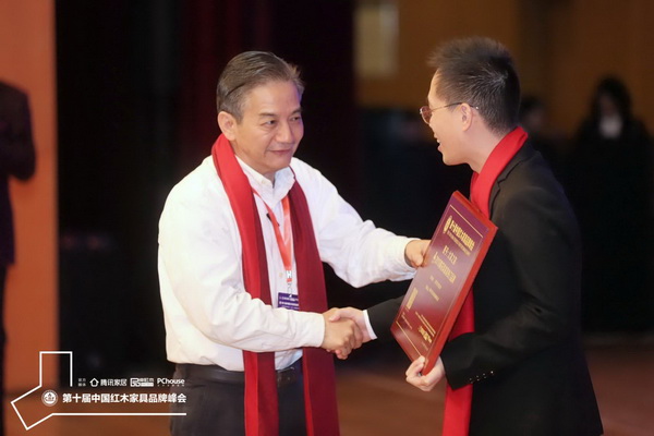 海南花梨文化研究會會長張志揚（左）為大家之家頒發(fā)“2019黃花梨家具熱門品牌”牌匾