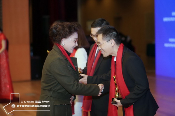 中國收藏家協會副會長維佳（左）為大家之家董事長助理徐住財頒發(fā)“2019紅木家具杰出青年企業(yè)家”獎杯