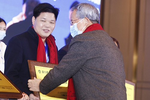 華南農(nóng)業(yè)大學(xué)博士生導(dǎo)師李凱夫（右一）為偉明軒紅木頒獎(jiǎng)，董事長張石乃（左一）上臺領(lǐng)獎(jiǎng)