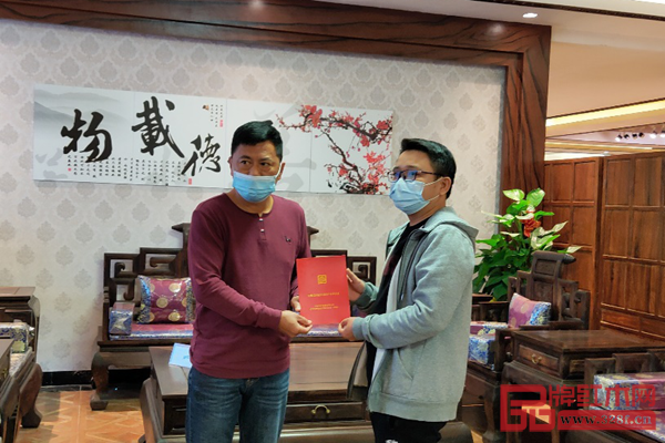 中國紅木消費權益保障工程（廣東）副主任鄧欽昌（左）為居典紅木消費者葉先生（右）頒發(fā)“紅木家具產權證”，并在購買的家具前合照