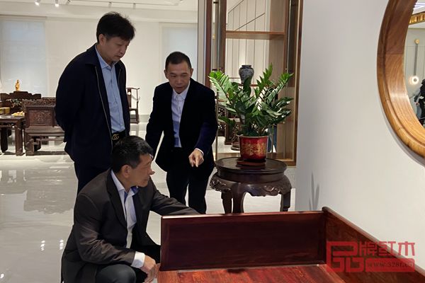 中國傳統工藝大師、波記紫檀館董事長伍建波(右一)在為嘉賓們介紹印度小葉紫檀家具的制作工藝與文化內涵 中國傳統工藝大師、波記紫檀館董事長伍建波(右一)在為嘉賓們介紹印度小葉紫檀家具的制作工藝與文化內涵