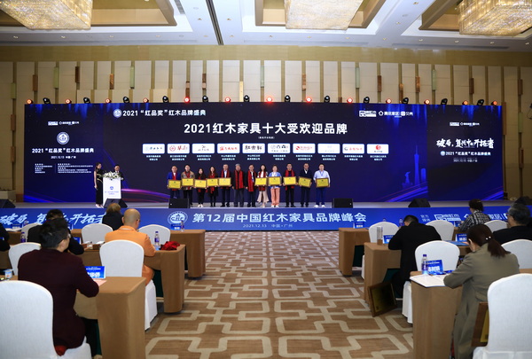 第十一屆全國政協委員、國家文物局原副局長張柏（中）為志成紅木總經理湯朝陽（右五）頒發“2021紅木家具十大受歡迎品牌”榮譽牌匾