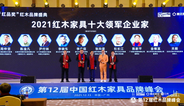 國(guó)家文化部原副部長(zhǎng)、國(guó)家博物館首任館長(zhǎng)潘震宙（左三）為“2021紅木家具十大領(lǐng)軍企業(yè)家”頒獎(jiǎng)（部分獲獎(jiǎng)?wù)咭驗(yàn)橐咔槲茨艿綀?chǎng)）