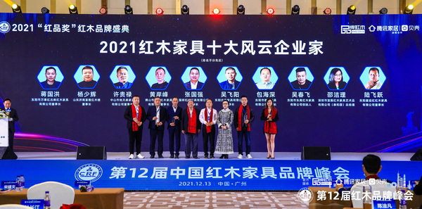 第十一屆全國(guó)政協(xié)委員、國(guó)家文物局原副局長(zhǎng)張柏（左四）、中國(guó)收藏家協(xié)會(huì)副會(huì)長(zhǎng)維佳（右三），為“2021紅木家具十大風(fēng)云企業(yè)家”頒獎(jiǎng)（部分獲獎(jiǎng)?wù)咭驗(yàn)橐咔槲茨艿綀?chǎng)）