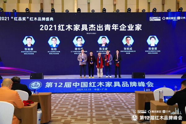 全聯(lián)藝術(shù)紅木家具專業(yè)委員會(huì)專家顧問(wèn)、中國(guó)高等教育家具設(shè)計(jì)專業(yè)創(chuàng)始人胡景初（左三）為“2021紅木家具杰出青年企業(yè)家”頒獎(jiǎng)（部分獲獎(jiǎng)?wù)咭驗(yàn)橐咔槲茨艿綀?chǎng)）