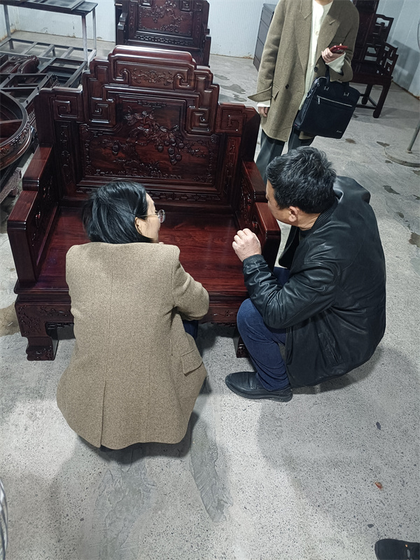 東陽市副市長龔杭娟（左）在喜迎紅紅木董事長陸飛躍（右）講解下近距離了解觀察水性漆紅木家具