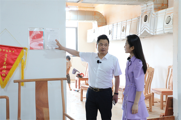全國工商聯藝術紅木家具專業委員會主席團主席、浙江省工藝美術大師、李忠信紅木董事長李忠信(左)給主持人講解流動紅旗機制 全國工商聯藝術紅木家具專業委員會主席團主席、浙江省工藝美術大師、李忠信紅木董事長李忠信(左)給主持人講解流動紅旗機制